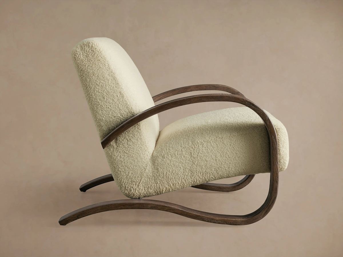Allora Chair with a light beige cushion, curved dark Mocha finish oak armrests, and an angled view from the back.
