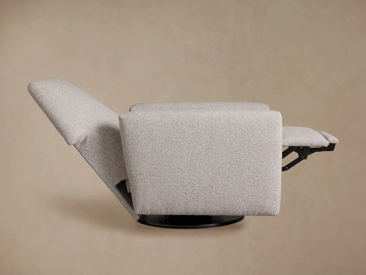 Back view of Harvey Swivel Recliner in light gray textured fabric with a high back and square arms, on a black swivel base.