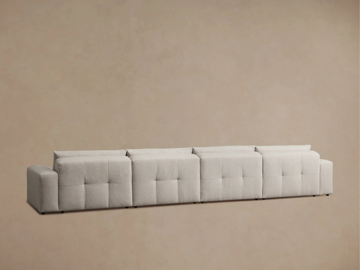 Back view of the Keegan Six-Piece Sectional in light gray fabric, showcasing its rounded and plush cushions with visible stitching.