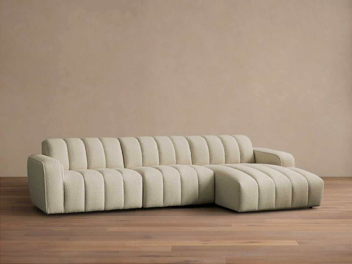 Front view of a cream Bracco Three-Piece Chaise Sectional with vertical channel tufting, textured fabric, and a right-facing chaise.