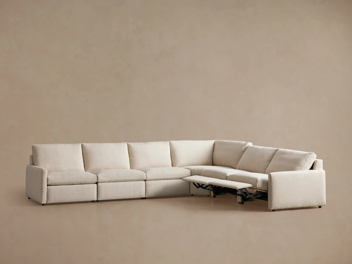 Kipton Slim Arm Six-Piece Motion Sectional in light beige fabric, L-shaped, with three left footrests extended.