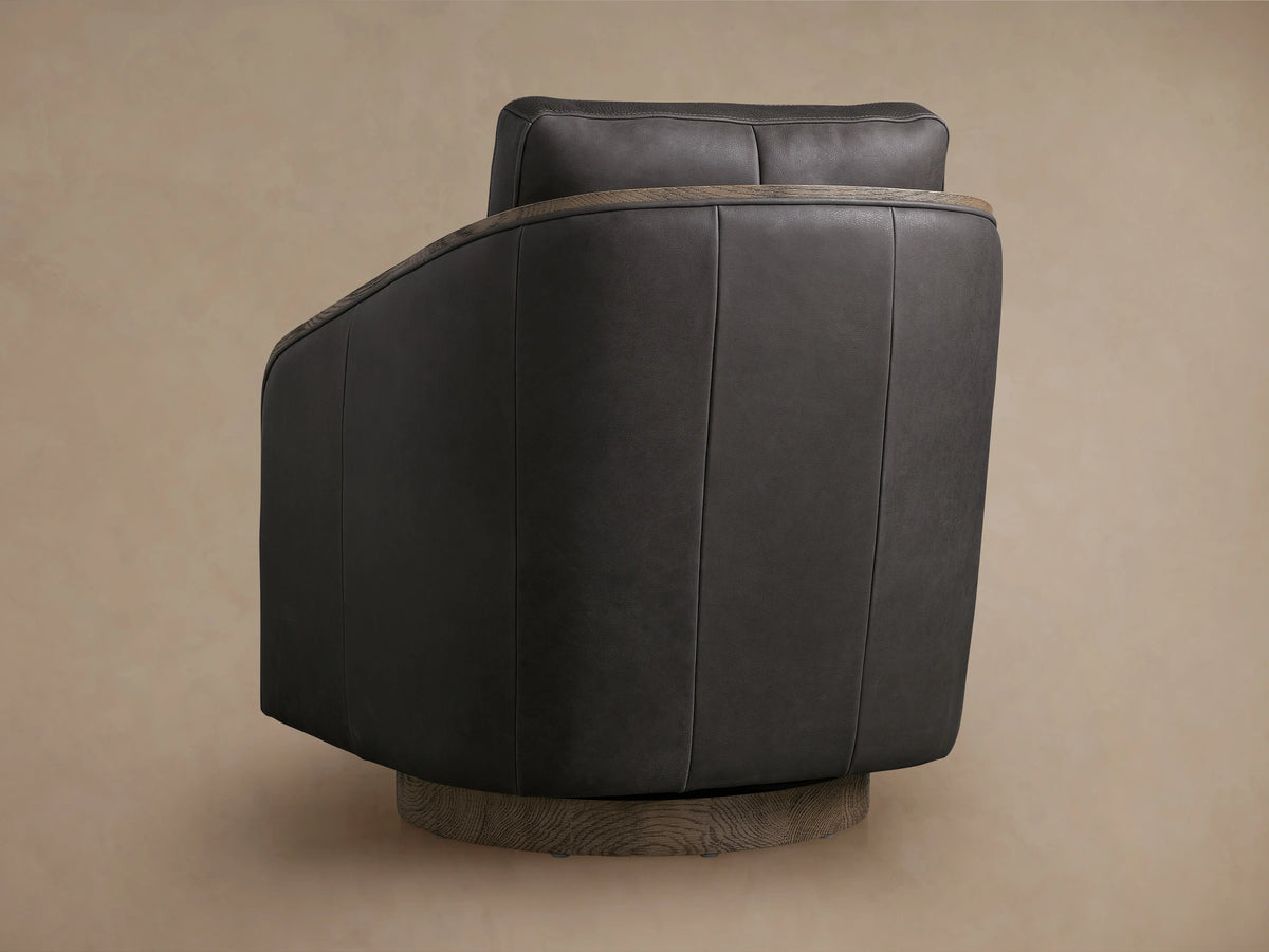 Pomona Leather Swivel Chair in dark brown leather with exposed oak edges on arms and base, featuring soft cushions.
