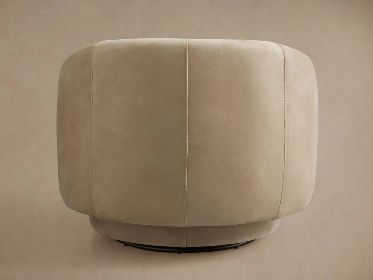 Hamlin Nubuck Leather Swivel Chair in light beige, side view, highlighting curved backrest and smooth leather texture.