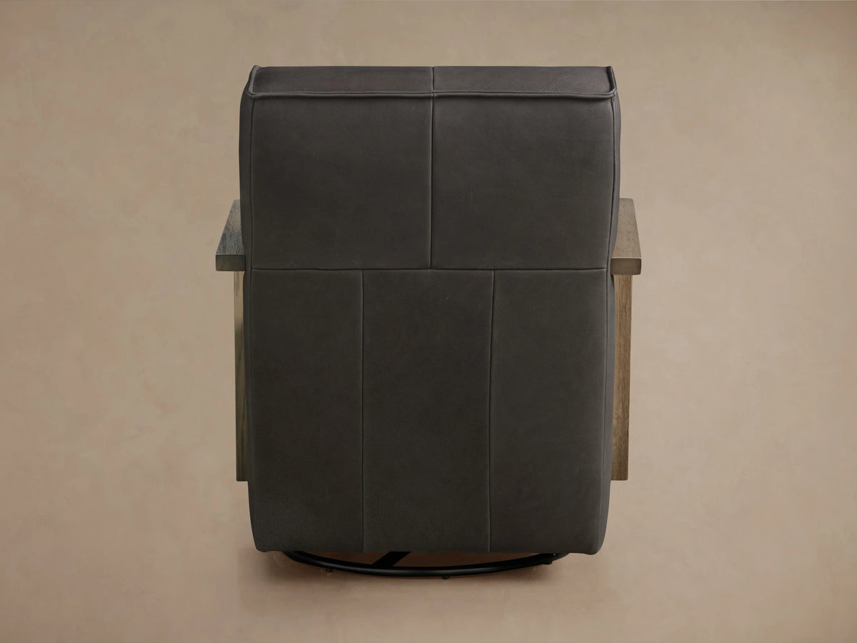 Walsh Leather Glider in dark brown leather, back view showing smooth panels, light wood armrests, and circular base for swivel.