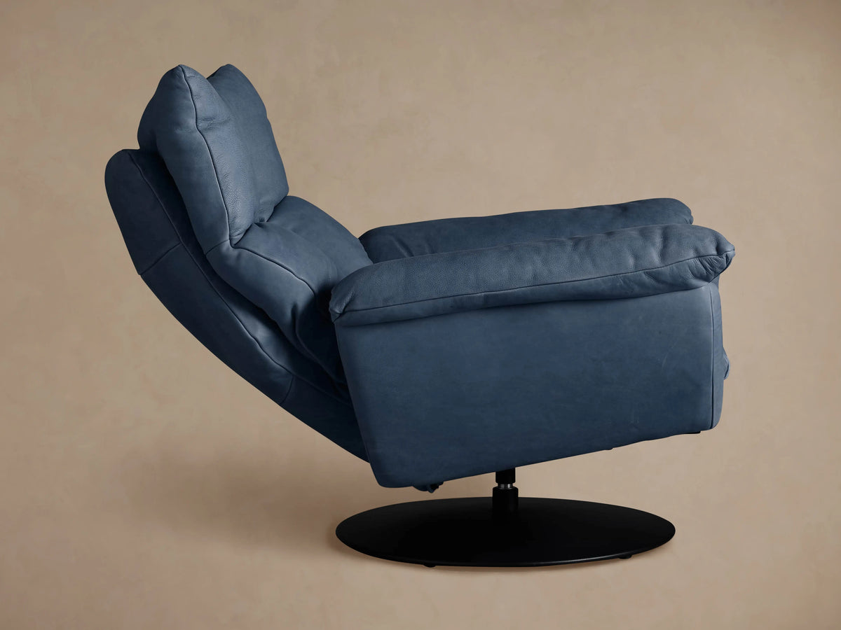 Deacon Leather Swivel Recliner in slate blue leather, shown from the right side profile. Plush back & arms, black swivel base.