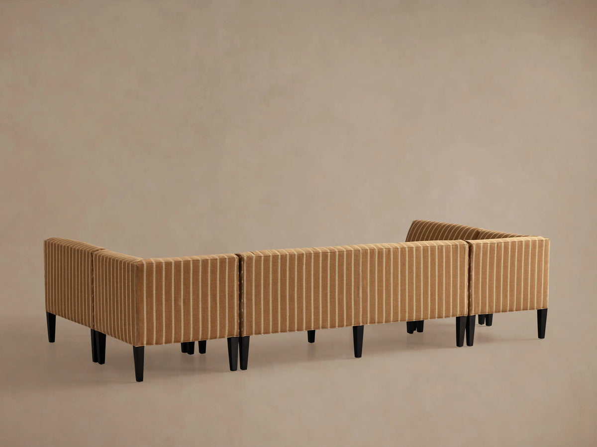 Eaton U-Shaped Banquette in light brown fabric with thin white dotted pinstripes, showing a corner section and dark wood leg.