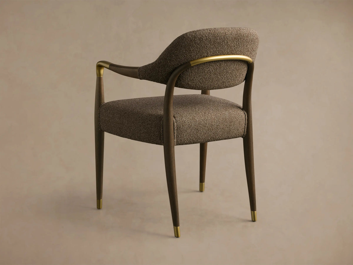 Rear-side view of the Evelyn Dining Arm Chair featuring dark mahogany wood, brown textured fabric, and brushed brass details.