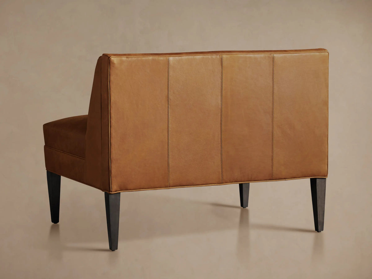 Close-up of Gates Leather Bench in warm brown, featuring vertical channel-stitched backrest and smooth seat.