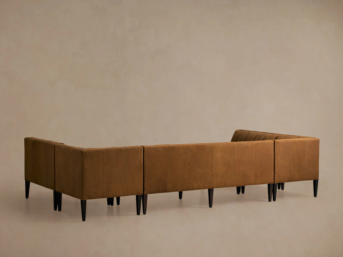 Close-up of a Gates Leather U-Shaped Banquette in rich cognac leather, showing channel-stitched backrests & flat seats.