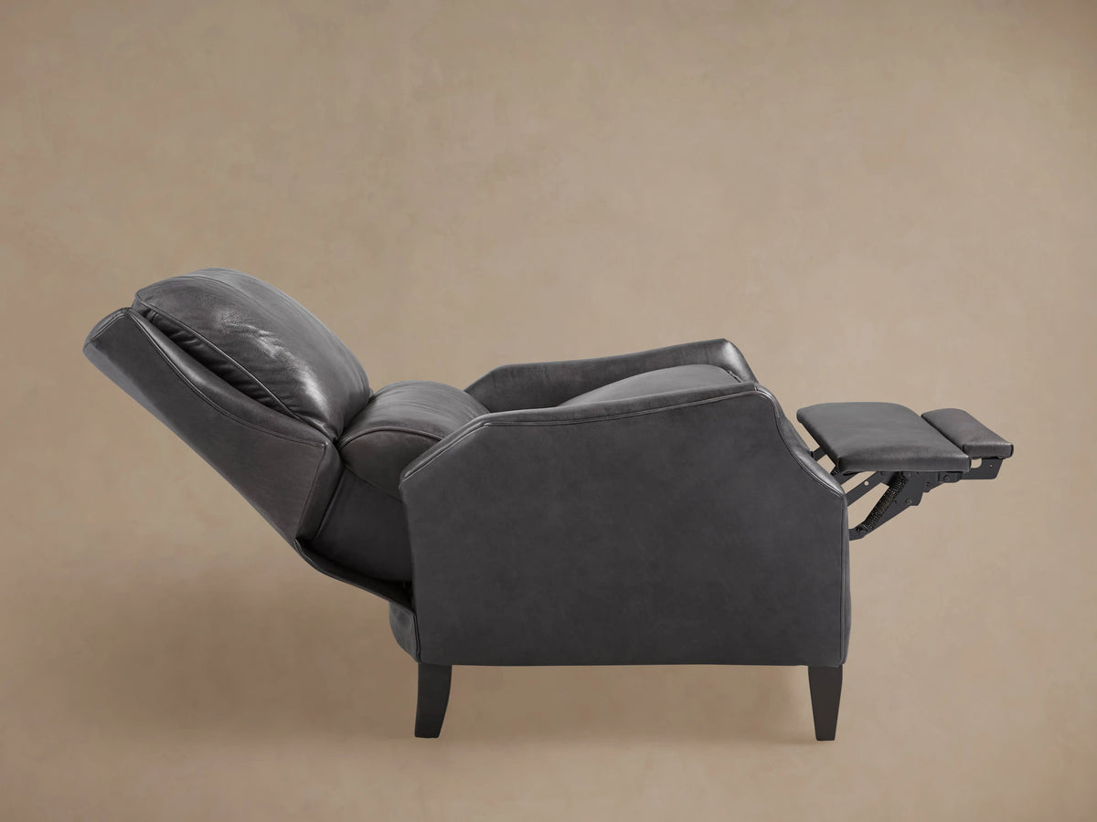 Side view of Alex Leather Recliner, dark gray leather, slightly reclined, with cushioned back and dark tapered wooden legs.