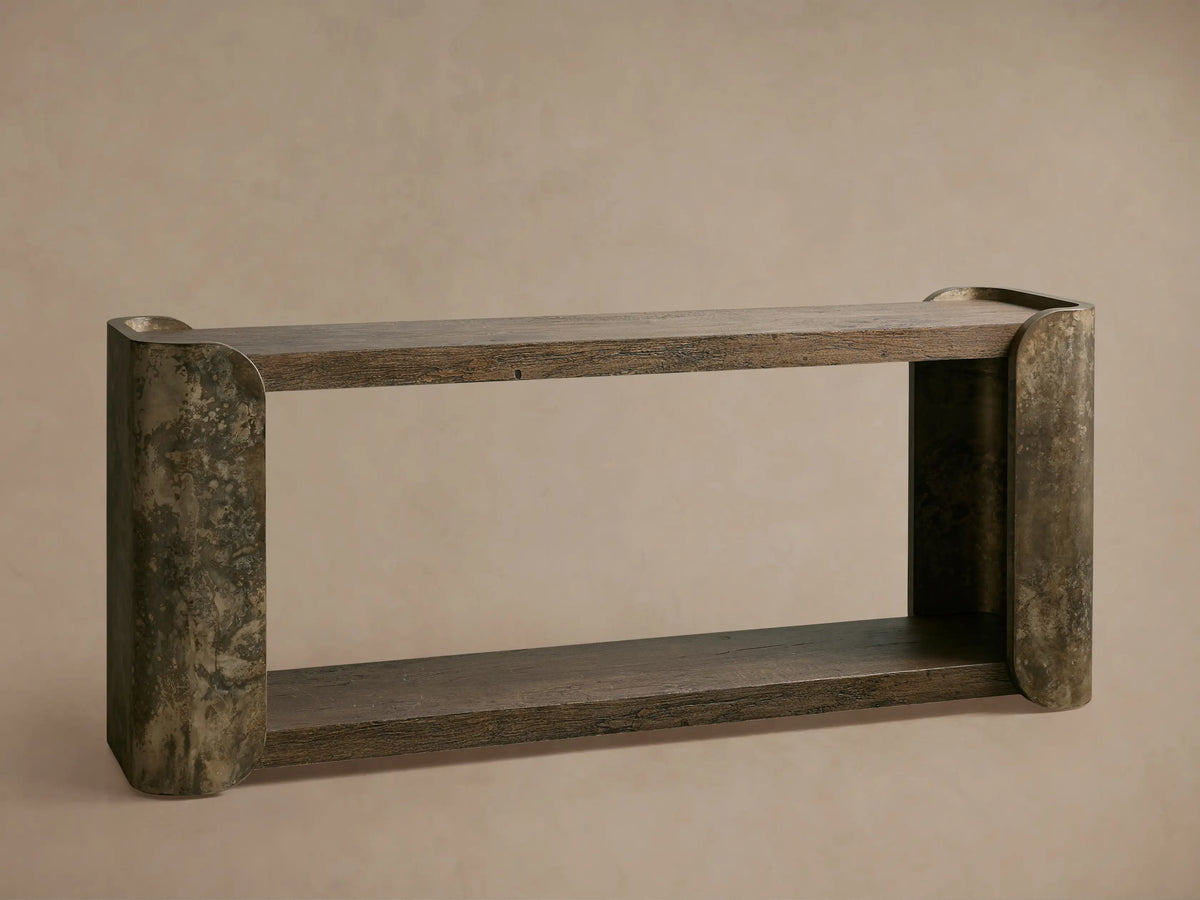 Close-up of Alvaro Console Table. Dark spalted primavera wood top with natural grain rests on weathered aluminum support.