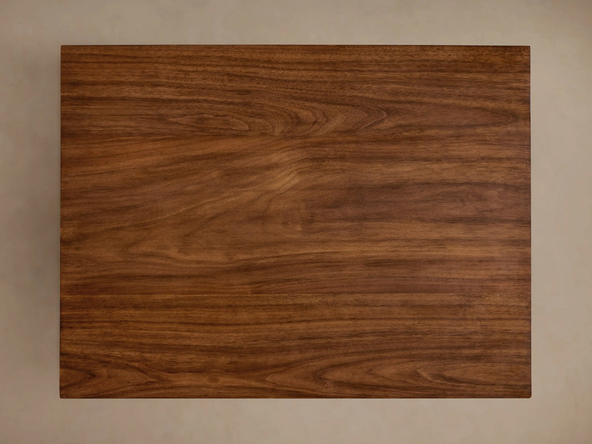 Ilaria End Table made of rich brown wood with a smooth, square tabletop and a tapered base. Smooth finish with visible grain pattern.