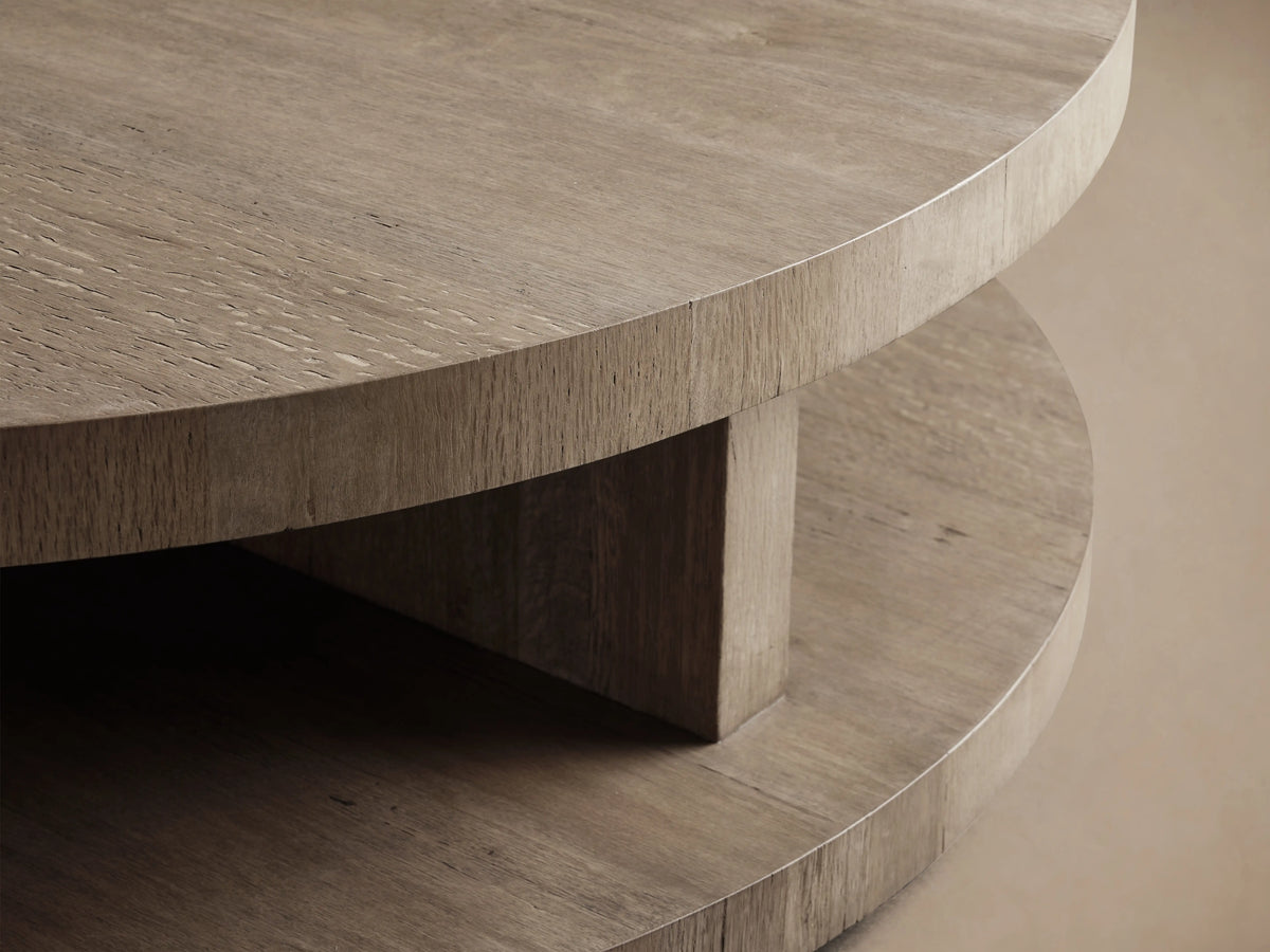 Round coffee table made from oak with a weathered finish. Features include thick, stacked circular surfaces and a natural wood texture.