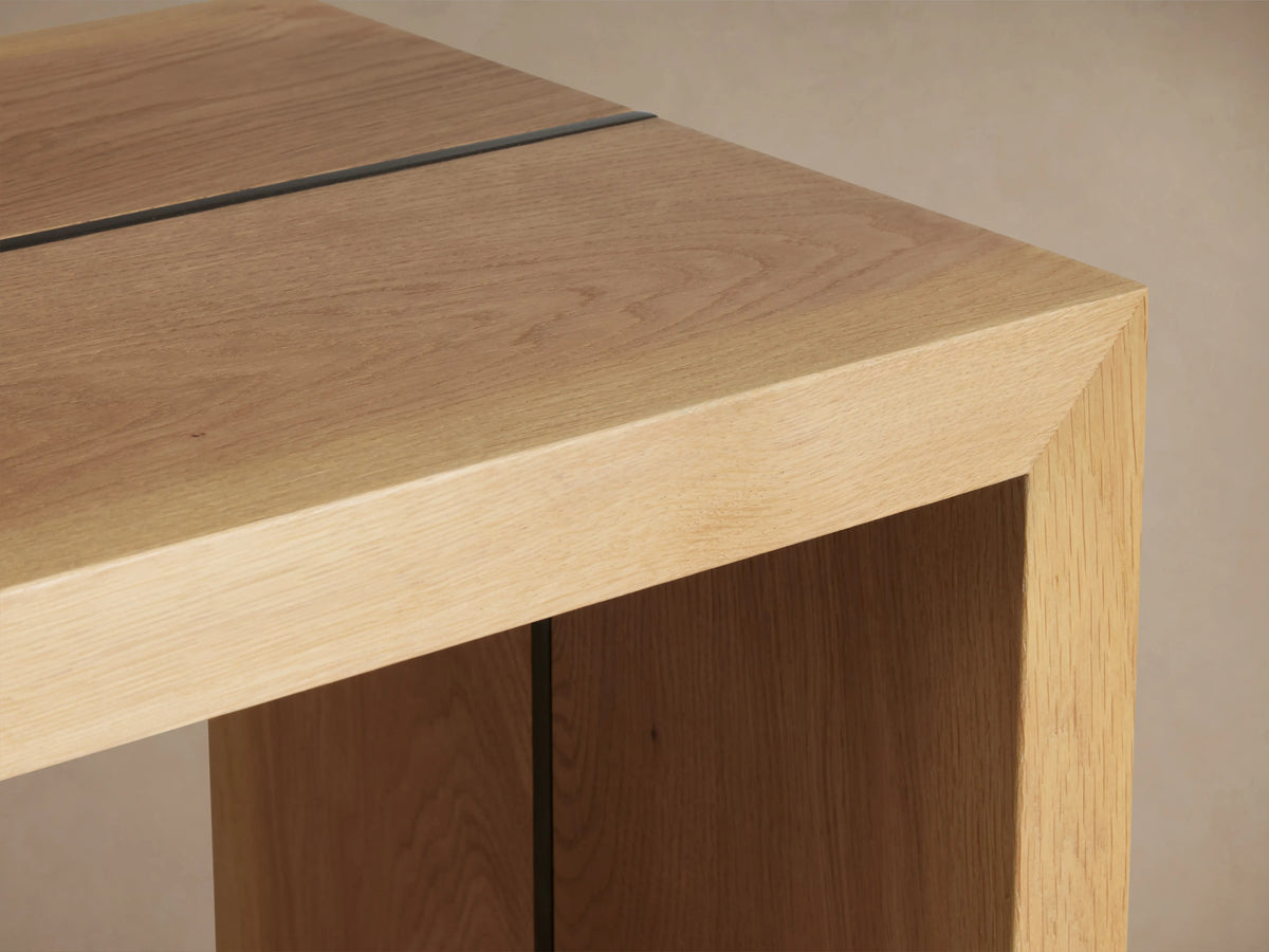 Mihaela Console Table in Vin Alb, rectangular, light wood finish, open frame design on wooden floor against beige wall.