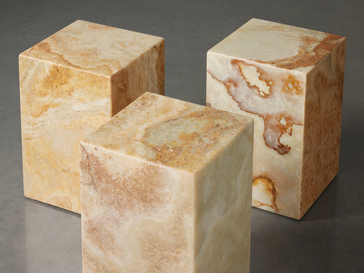 Close-up Rust Onyx Stool. Polished ivory stone with organic rust and light green patterns visible on top and side.