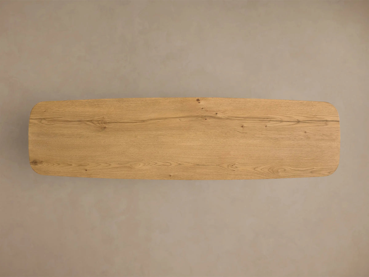 Close-up of the light brown oak Redding Console Table, highlighting the natural wood grain, rounded edge, and lower shelf.