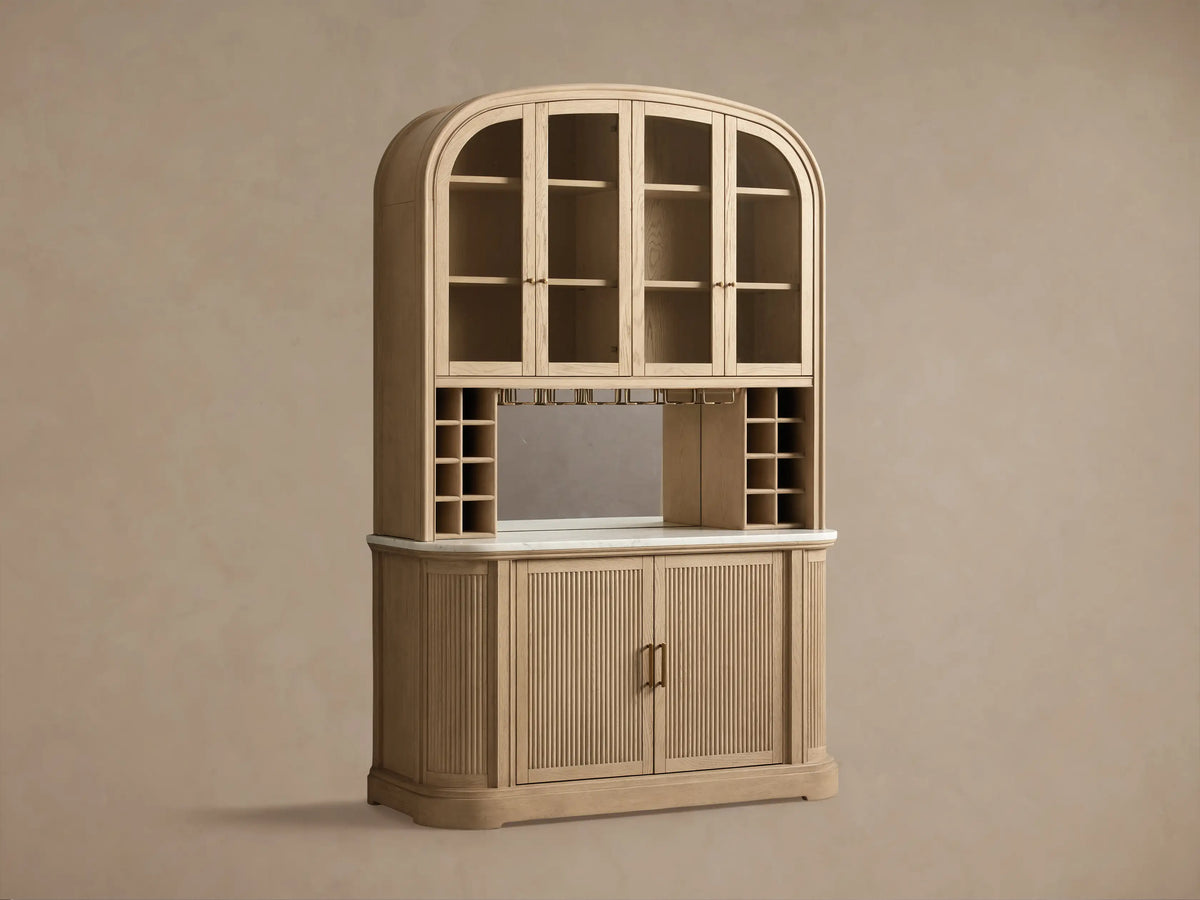 Coventry Bar: light oak, arched glass-door top, mirrored back, wine racks, white marble, fluted wooden base, brass handles.