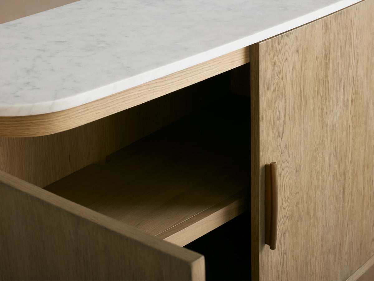 Danny Sideboard in oak wood with a light fawn finish, featuring four doors and brass-finished handles, topped with white marble.