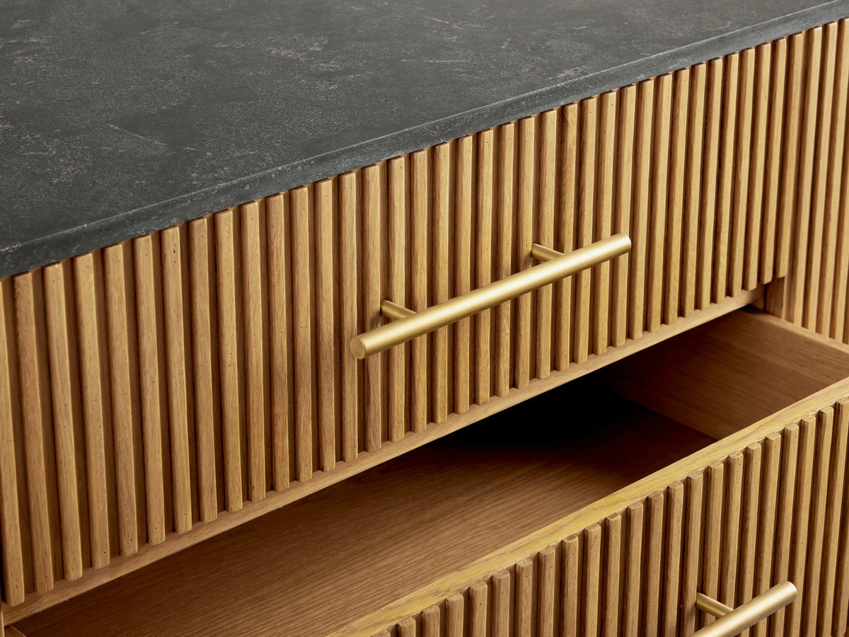 Finnley 100" Sideboard with a honey finish features vertical slats, bluestone top, open drawer and cabinet, and brass-finished hardware.