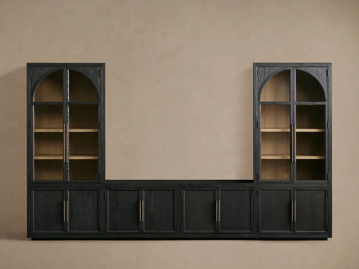 Close-up of Hattie Glass Media Cabinet, dark black oak with visible grain. Lower door open shows light wood interior shelf. Antiqued bronze hardware.