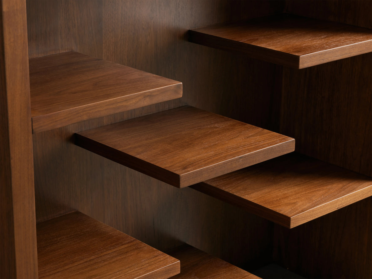 Floating walnut shelves of the James Bookcase, showcasing rich wood grain and smooth finish, staggered arrangement.