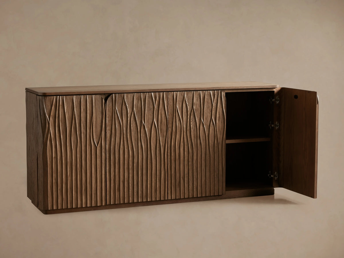 Norris Sideboard: Medium brown wooden sideboard with a flat top and four doors displaying a distinct wavy carved vertical pattern.