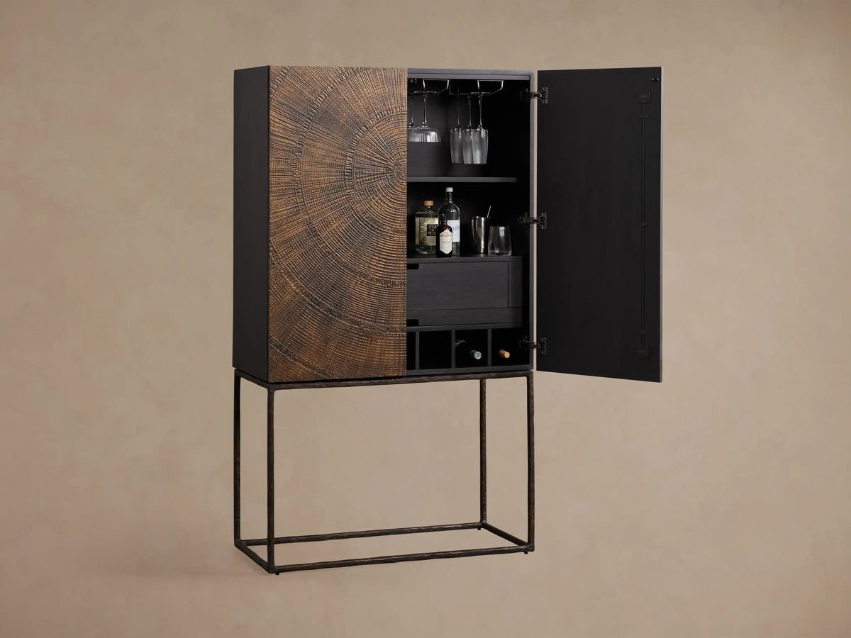 The interior of the Theota Bar Cabinet is shown with a black matte finish, featuring glassware, a jigger, and a cocktail shaker.