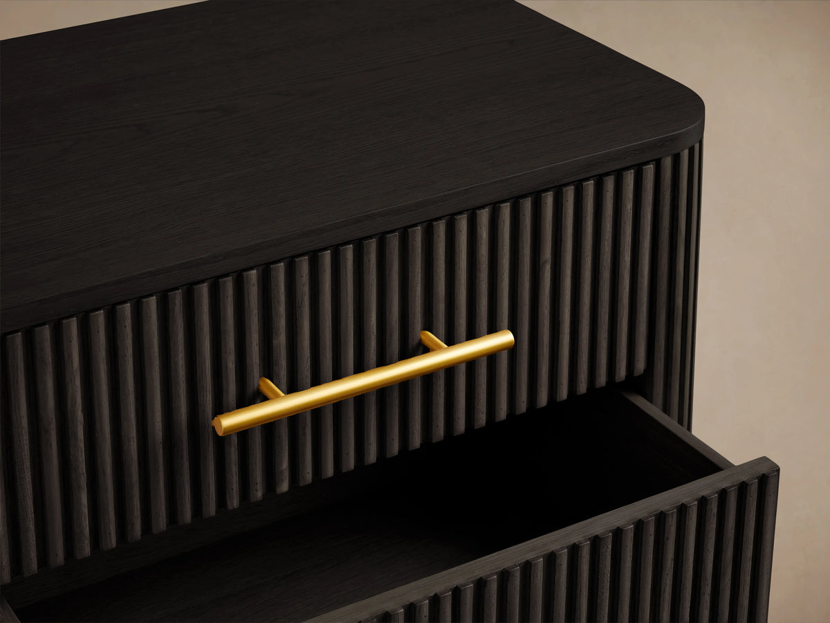 Finnley Wood Nightstand in Ebony finish with three ribbed drawers, each with a brass-finished handle, two drawers partially open.