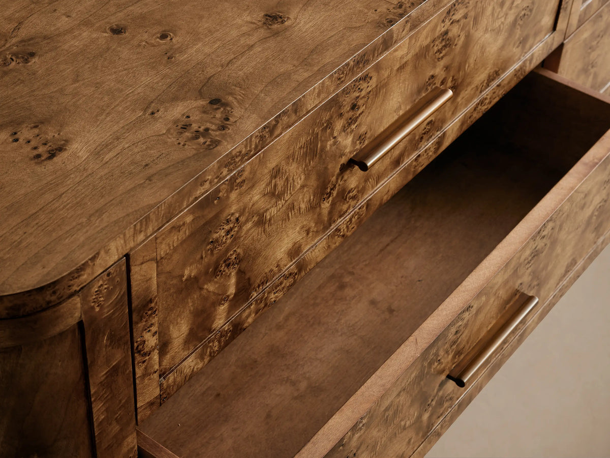 Front view of the Mogadore Six-Drawer Dresser, made from warm brown Mappa burl wood with unique grain and six drawers with antiqued brass handles.