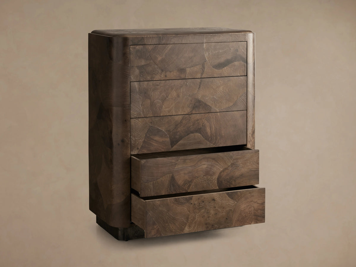 Polanco Five-Drawer Dresser made of dark wood with visible grain patterns. Three drawers closed, two slightly open, on a textured base.
