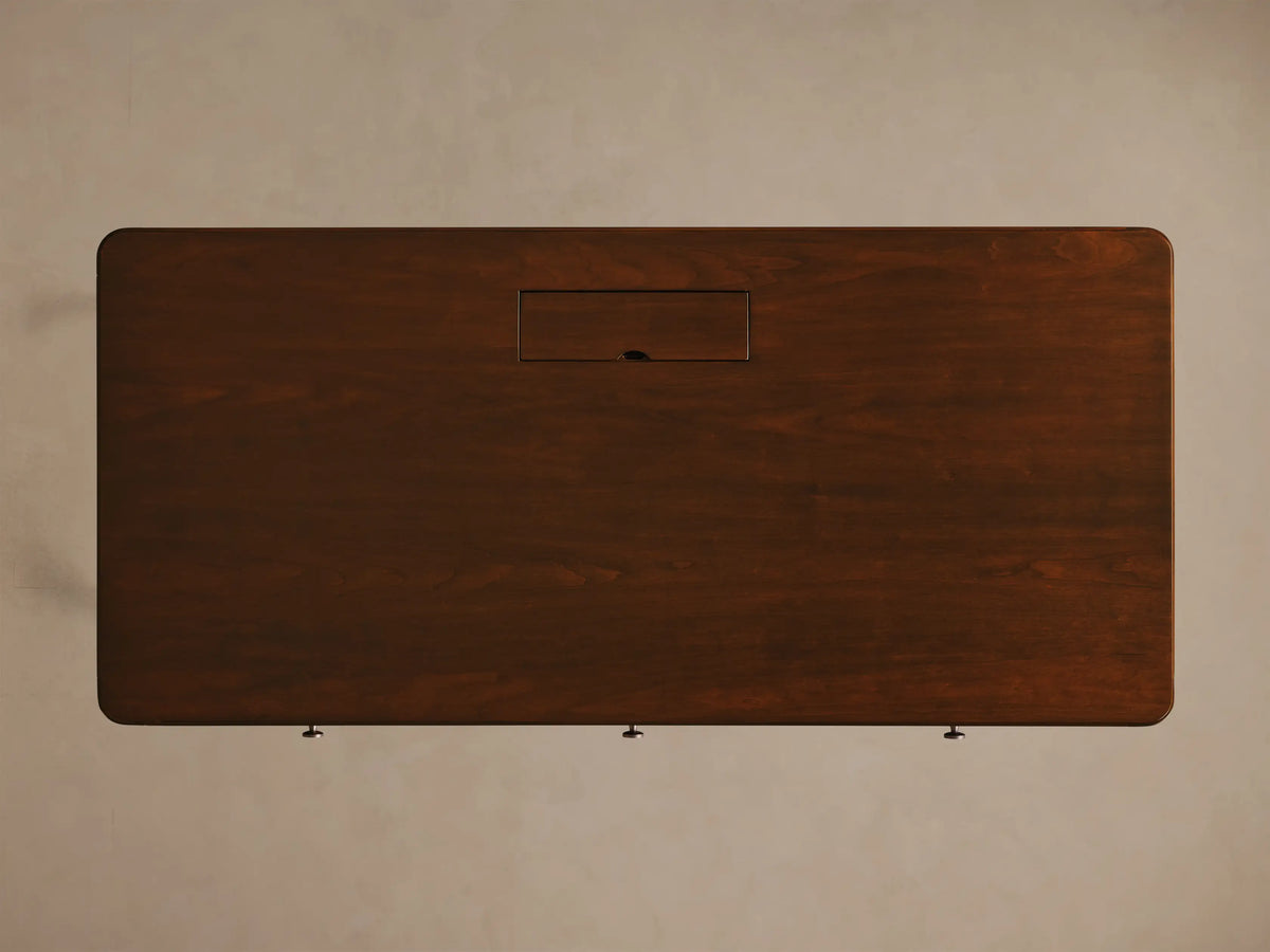 Front view of the Mahogany Executive Desk, featuring three drawers with silver pulls. Tapered legs have brass caps.