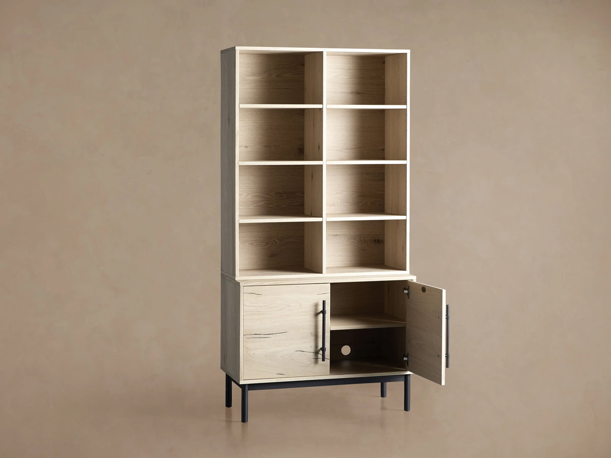 Interior view of Sullivan Bookcase cabinet in light oak, showing wooden shelf and circular cord management hole at the back.