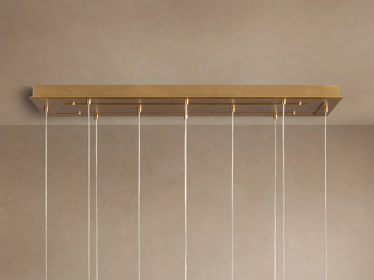 Casen Linear Chandelier: Close-up of glowing white opal glass globes with satin brass fittings.