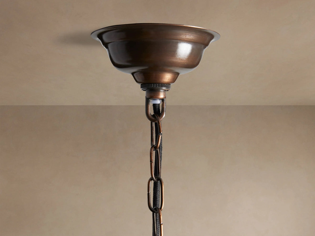 Laila Pendant: cylindrical light with vertical antiqued mirrored-glass panes in an antique copper frame, glowing warmly from within.