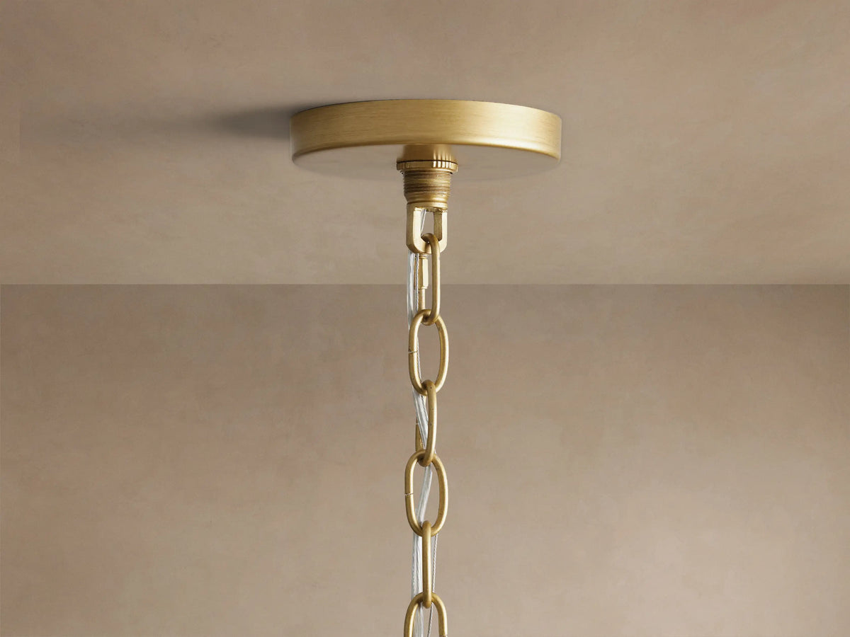 Margolis Small Pendant: close-up of glossy white hand-blown glass shade within a curved brass-finished iron frame & hanging ring.