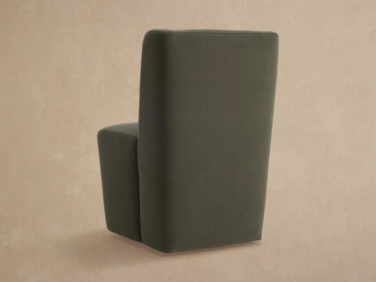 Close-up of Lina Outdoor Dining Chair in dark gray-green fabric, showing upholstered back and seat, angled view.