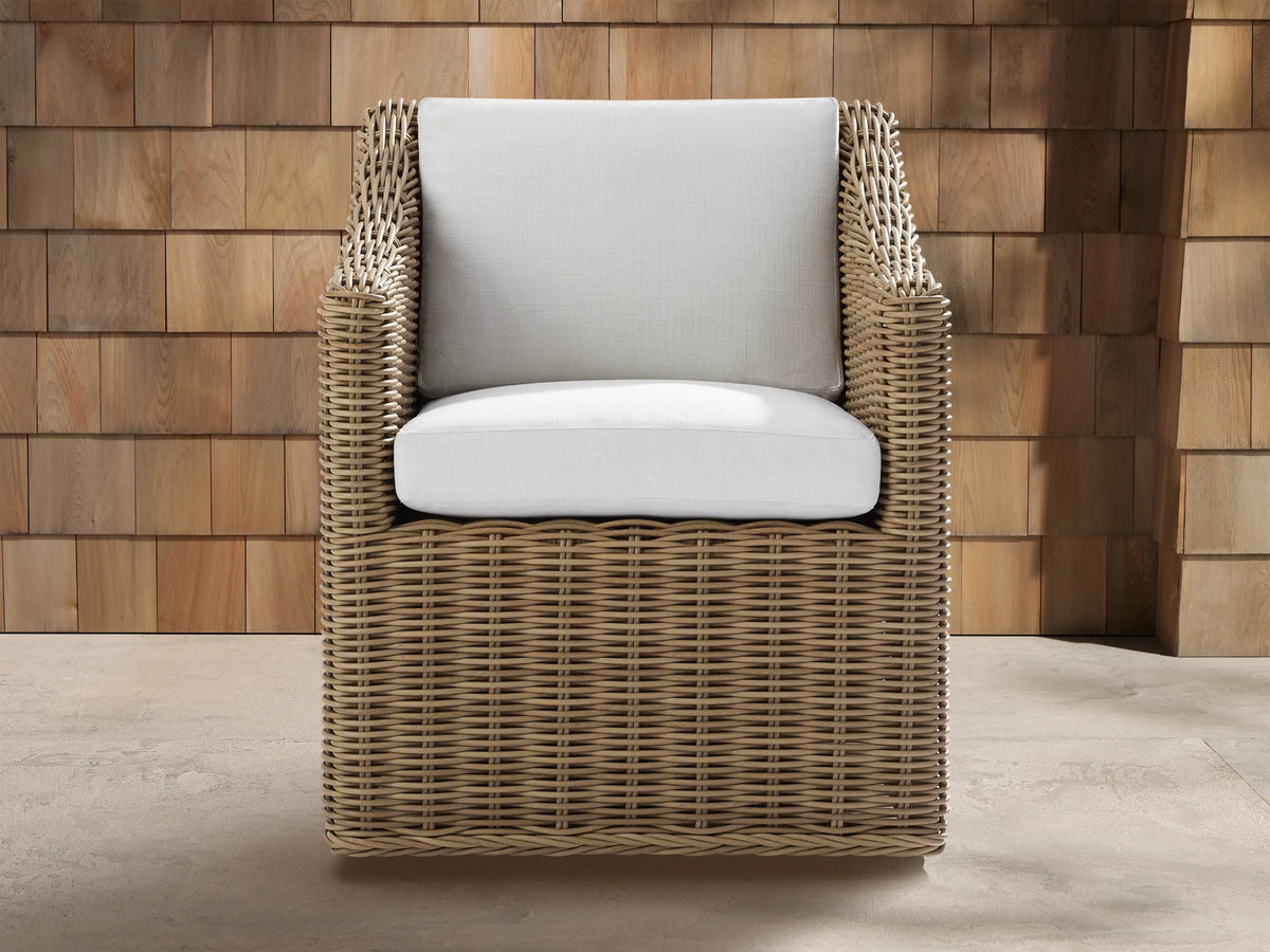 Montauk Outdoor Swivel Dining Arm Chair, front view, tan woven resin wicker with light off-white seat & back cushions.