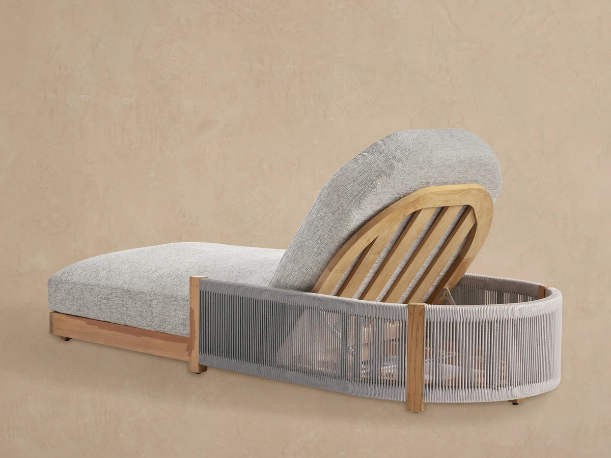 Close-up, angled view of Newport Outdoor Chaise. Inclined natural teak wood slatted backrest, light gray rope frame, textured gray cushion.