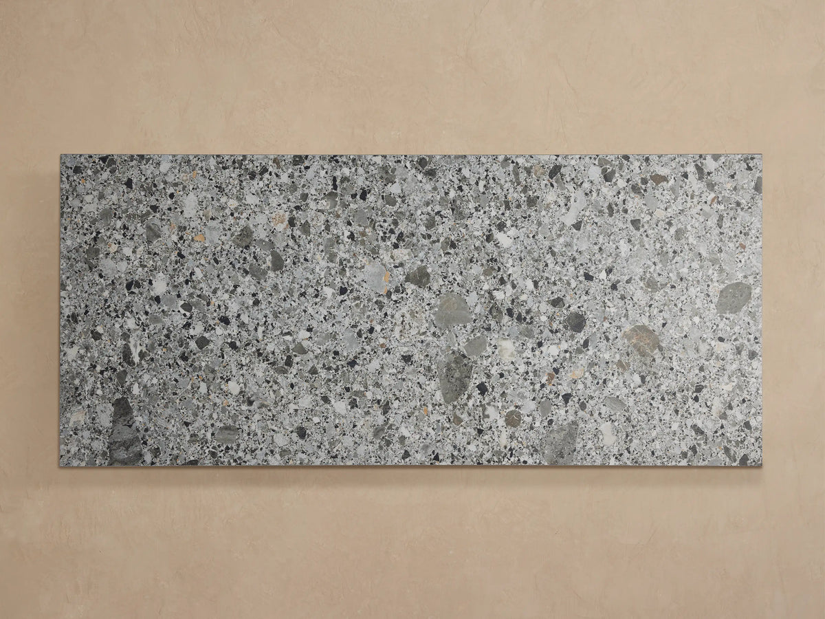 Paloma Outdoor Coffee Table with a speckled grey, black, and white sintered stone top and matte black aluminum frame.