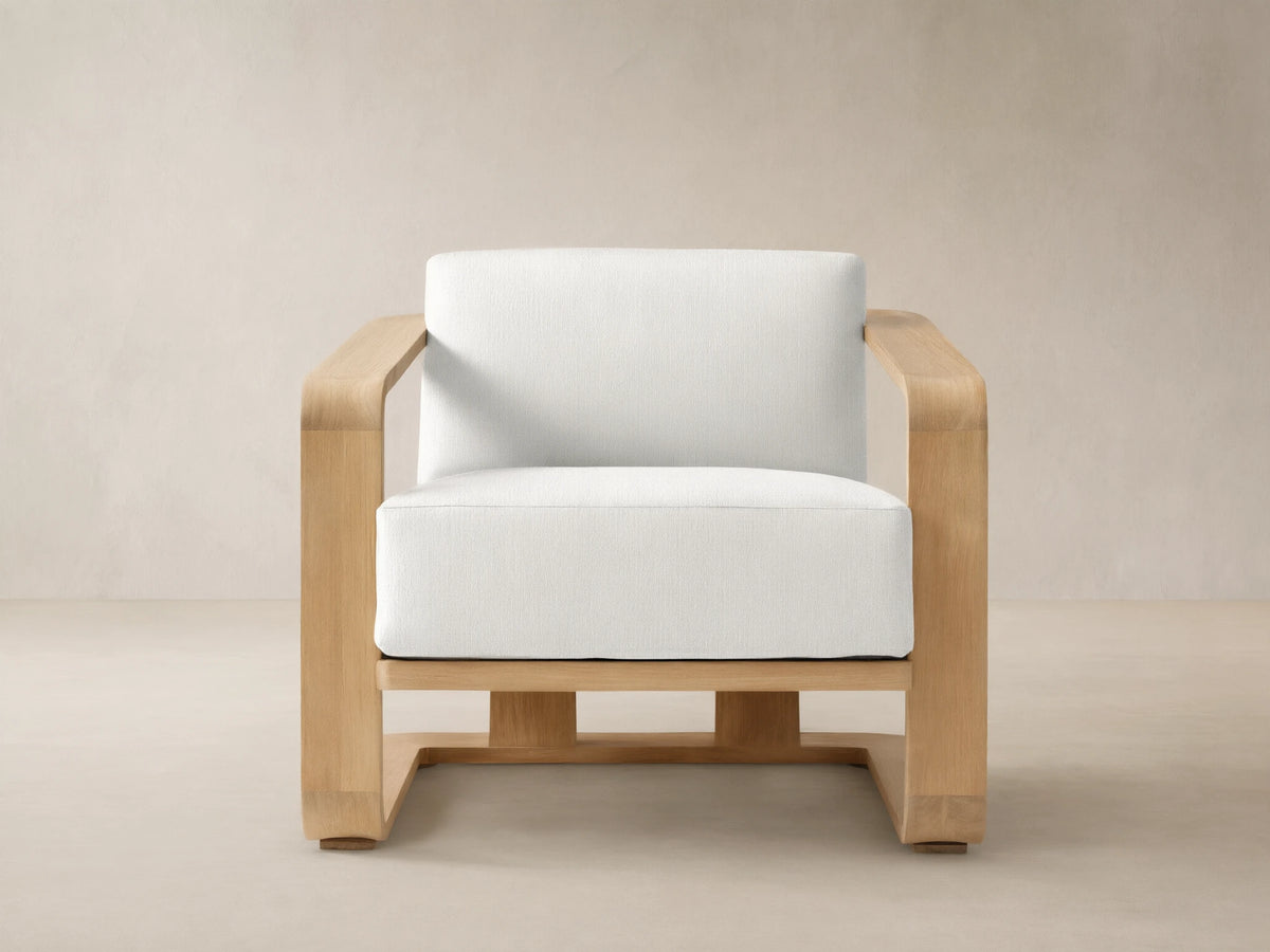 Sonoma Outdoor Teak Lounge Chair with a natural teak frame and thick white Savona Snow cushions, centered on a tiled floor.
