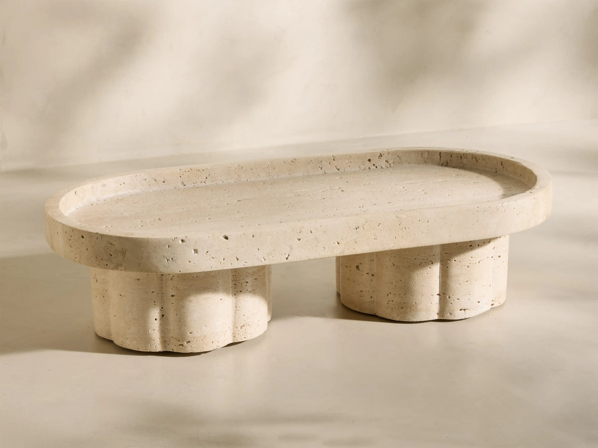 Close-up of the beige and ivory-toned travertine Sylvaine Footed Tray, showing natural texture and scalloped feet.