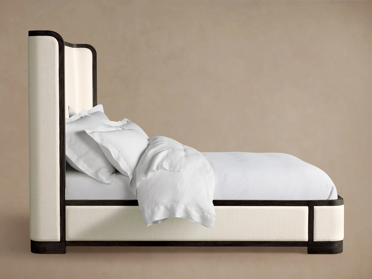Darien Curved Shelter Bed corner detail showing oak wood frame with dark finish and upholstered panel in light fabric.