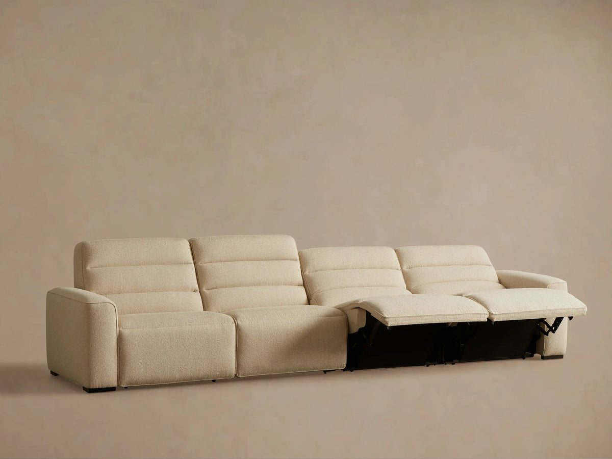 Front view of the beige textured fabric Borough Four-Piece Motion Sectional, with the left recliner's footrest extended.