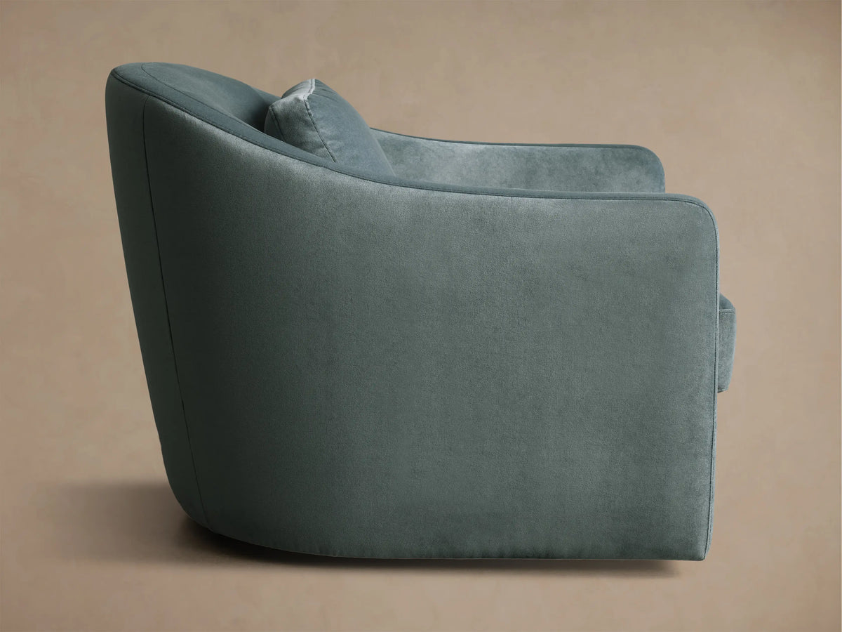 Rear view of the dusty teal Bianca Swivel Chair, showcasing its soft, textured fabric and gracefully curved backrest.