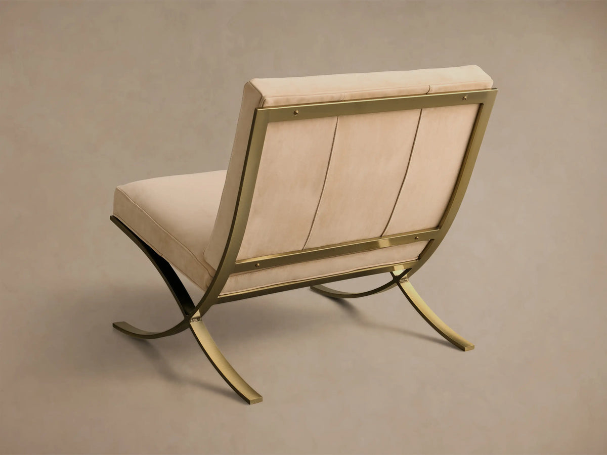 Rear view of a beige Moxie Leather Chair with a gold stainless steel frame and tufted back detail.