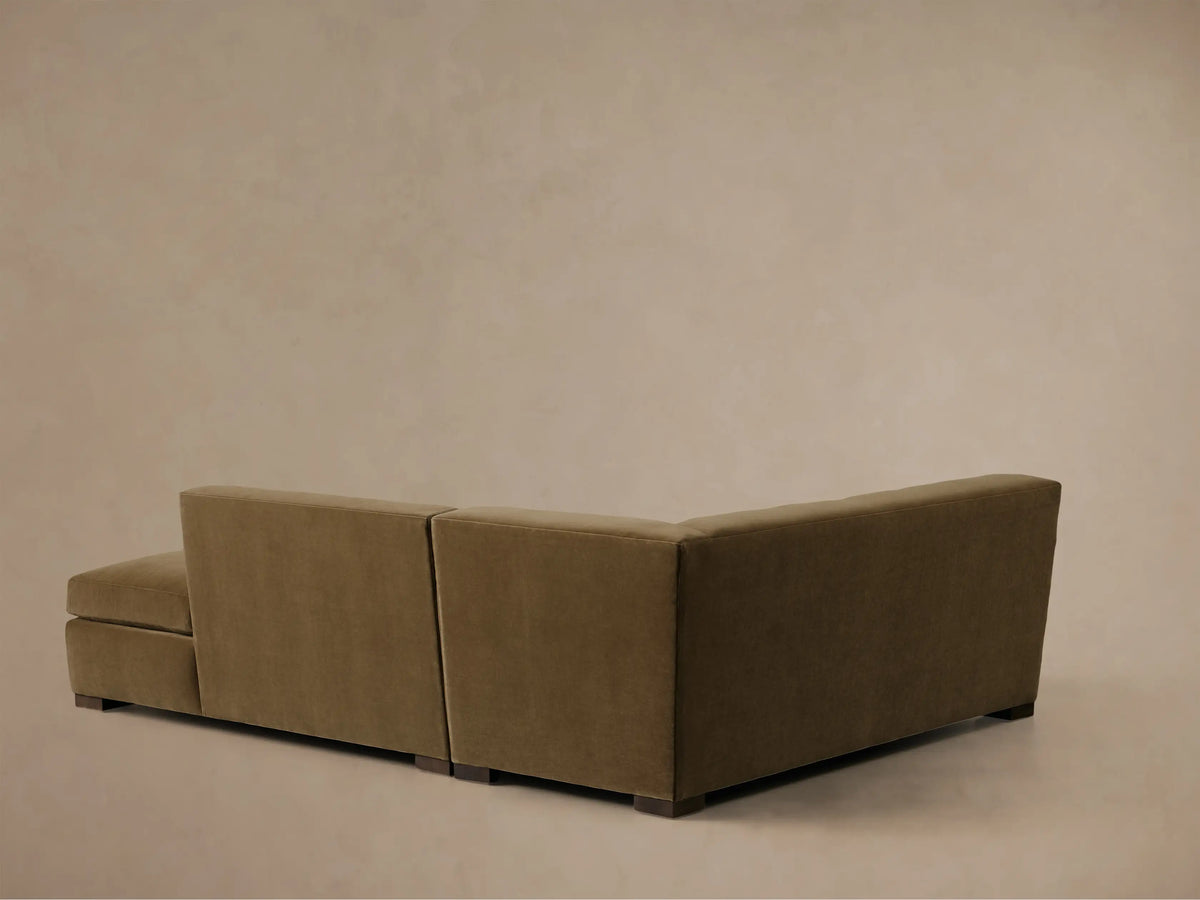 High-angle view of a tan Bronte Two-Piece Bumper Chaise Sectional with plush seat and back cushions, and a chaise on the right.
