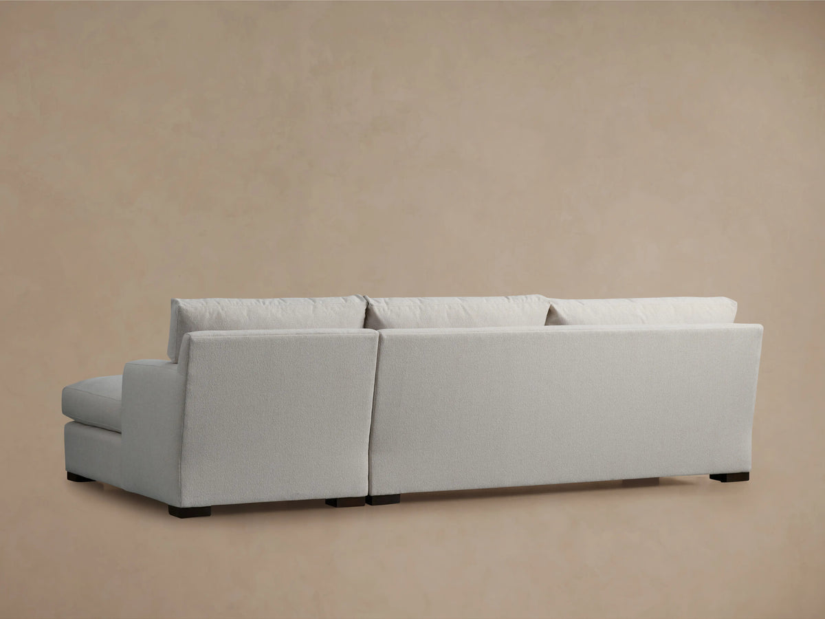 Zarevium Dune Two-Piece Chaise Sectional in light gray fabric with right-facing chaise, on a wood floor against a tan wall.