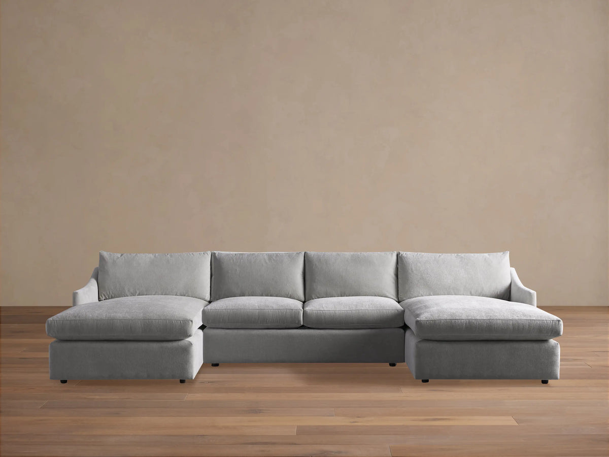 Front view of a plush, light gray Branson Three-Piece Double Chaise Sectional with deep cushions on wooden floor.