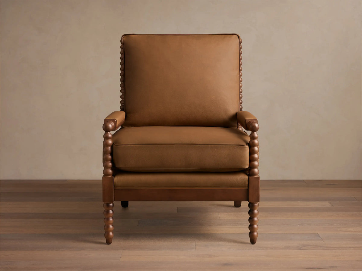 Rear view of the brown Milly Leather Chair, showcasing bobbin-turned spindle back and armrests.