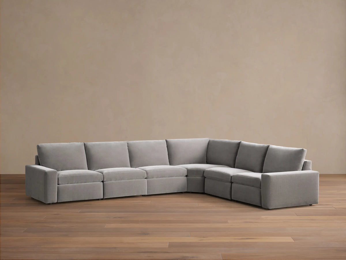 Front view of the light gray Kipton Wide Arm Six Piece Motion Sectional, with two reclined seats showing extended footrests.